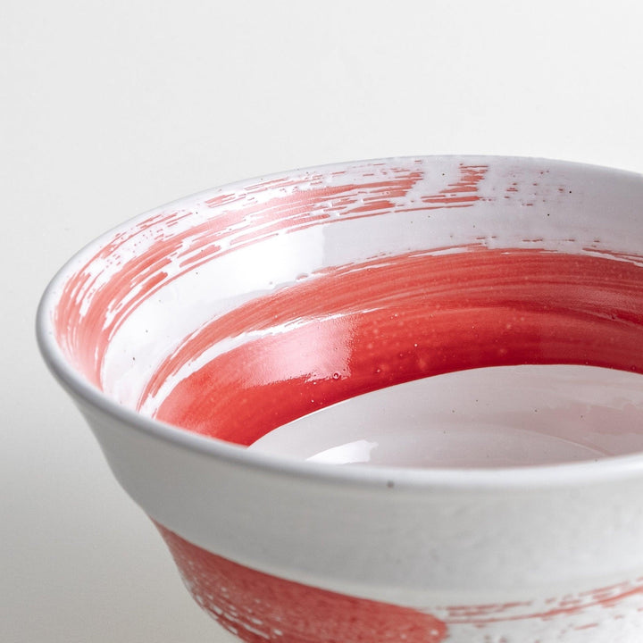 A white ramen bowl with a wide red brushstroke across its exterior.