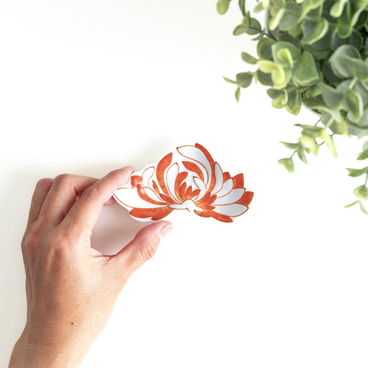 Orange chrysanthemum-shaped plate with gold outlining
