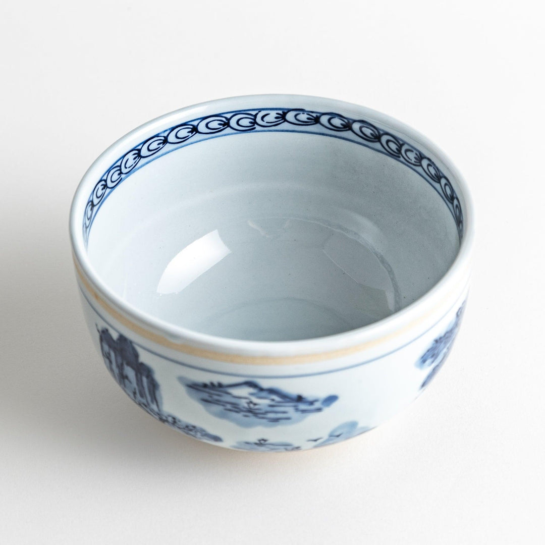 A bowl featuring a traditional blue and white landscape design.