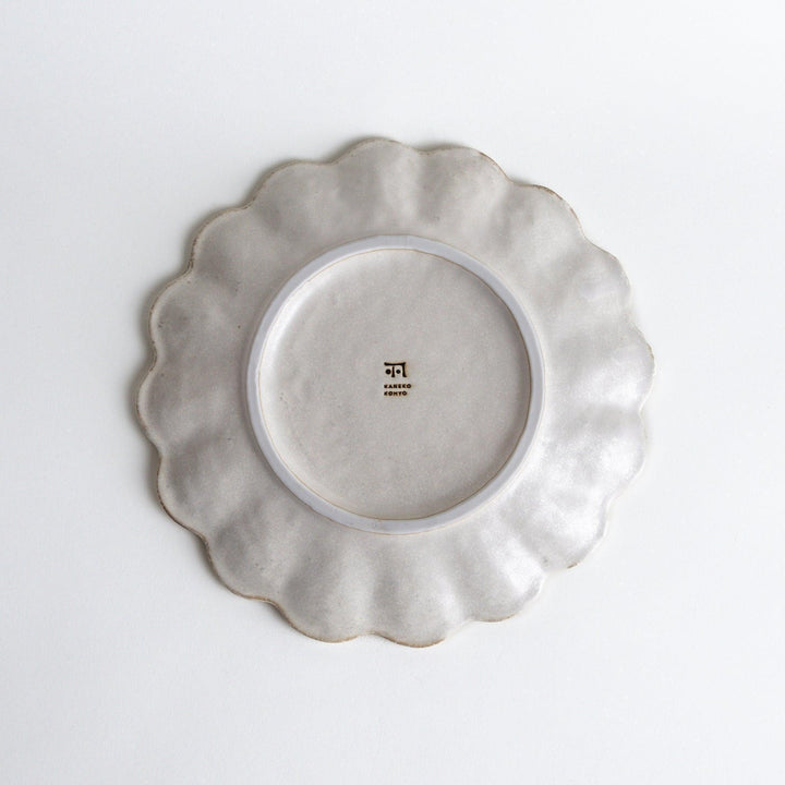 White ceramic dinner plates with scalloped flower-petal edges, available in black or white.