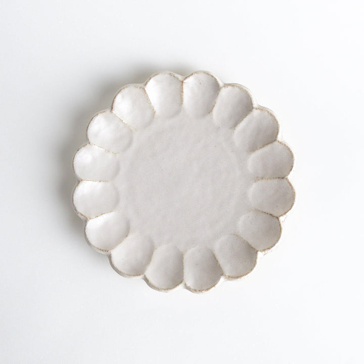 White ceramic dinner plates with scalloped flower-petal edges, available in black or white.