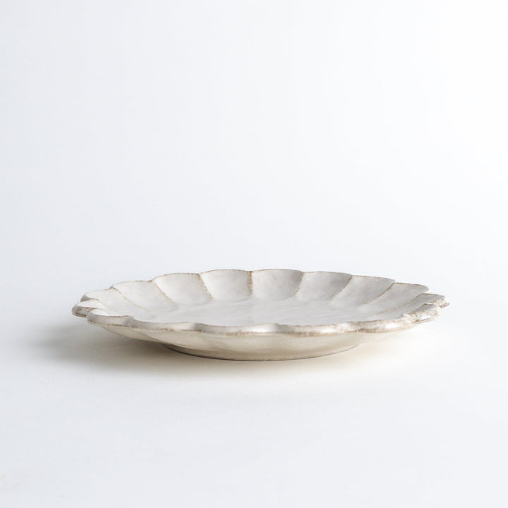 White ceramic dinner plates with scalloped flower-petal edges, available in black or white.