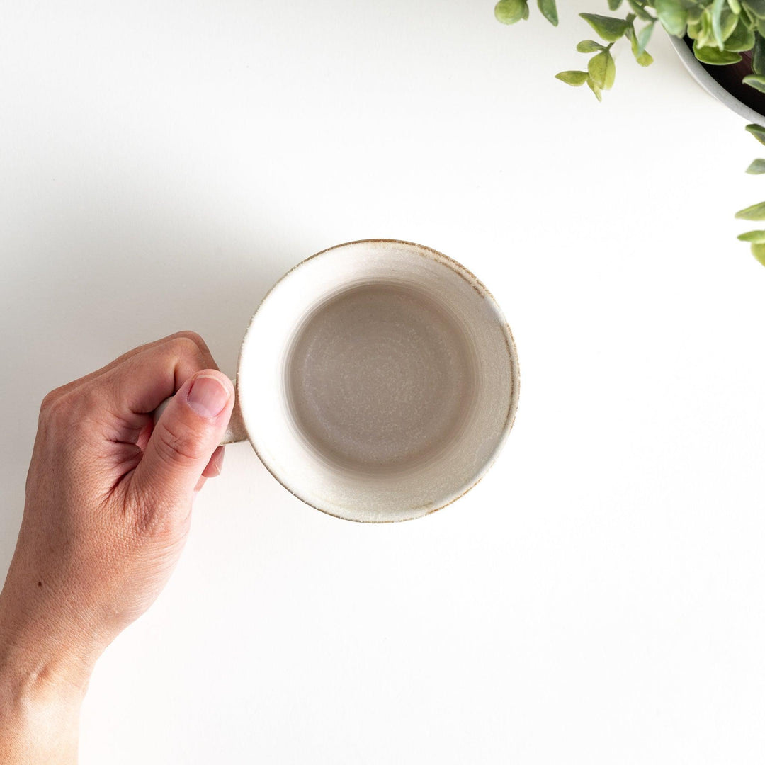 A minimalist ceramic mug with a textured, faceted finish. Available in black or white.