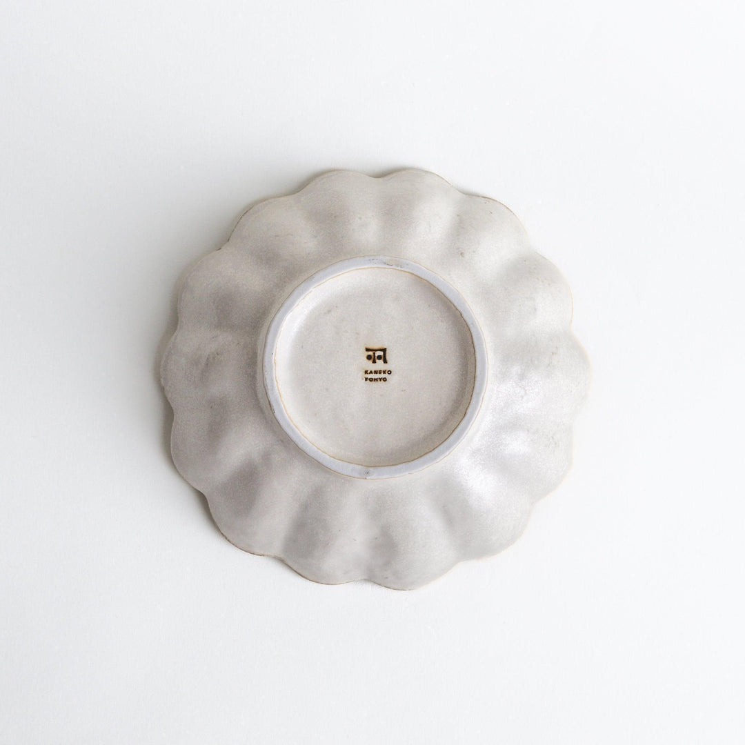 A white ceramic pasta bowl with a scalloped flower-petal design.