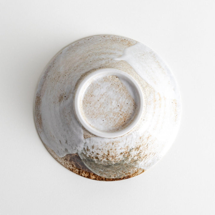 A large bowl with a speckled cream and brown glaze, featuring an organic, earthy design.