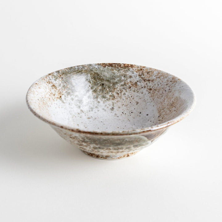 A large bowl with a speckled cream and brown glaze, featuring an organic, earthy design.