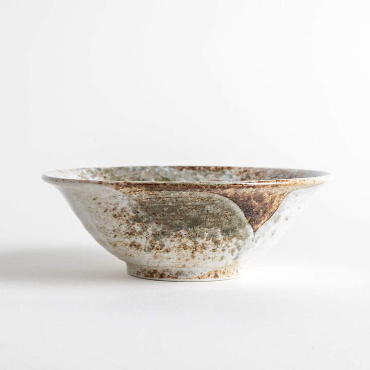 A large bowl with a speckled cream and brown glaze, featuring an organic, earthy design.