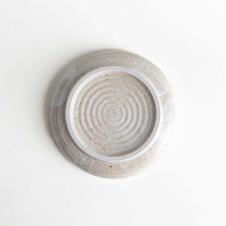 A pasta bowl with a speckled cream and brown glaze, displaying an earthy, organic design.