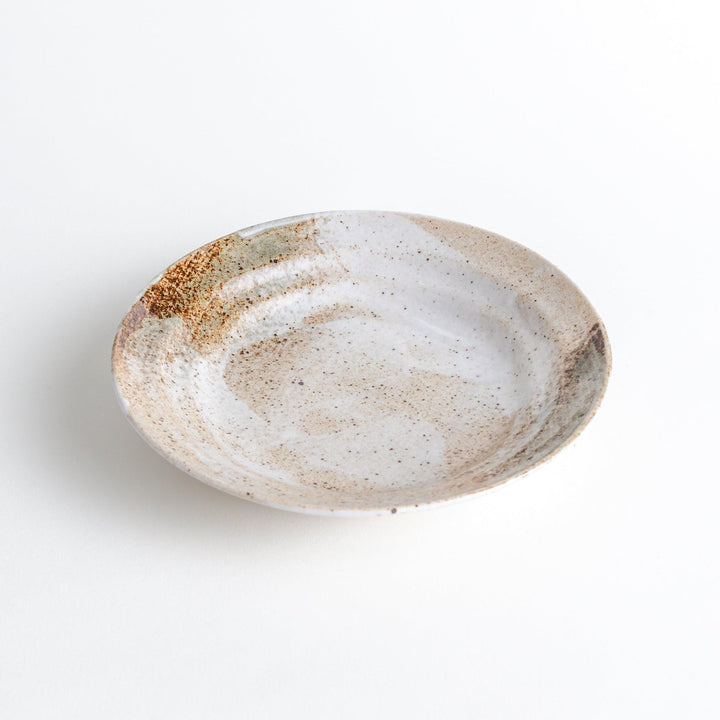 A salad plate with a speckled cream and brown glaze, featuring an earthy, organic design.