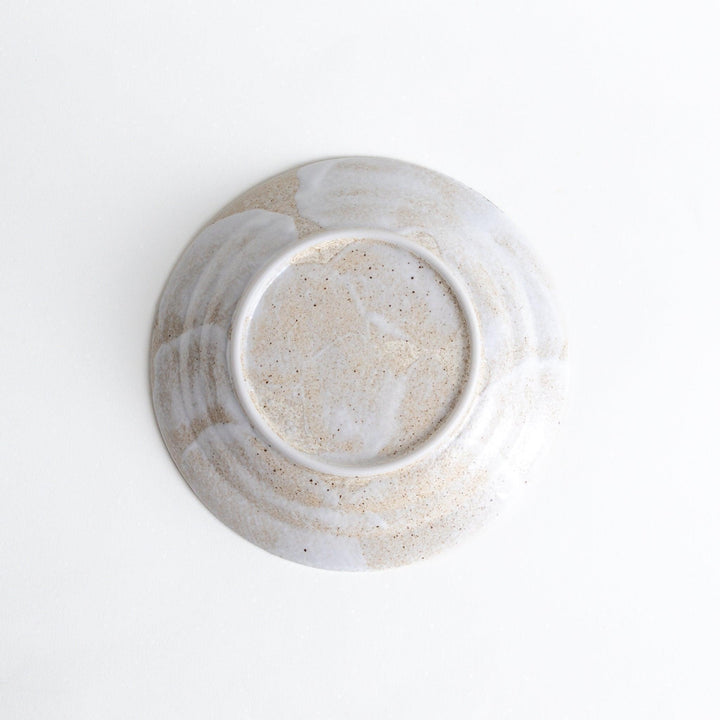 A salad plate with a speckled cream and brown glaze, featuring an earthy, organic design.