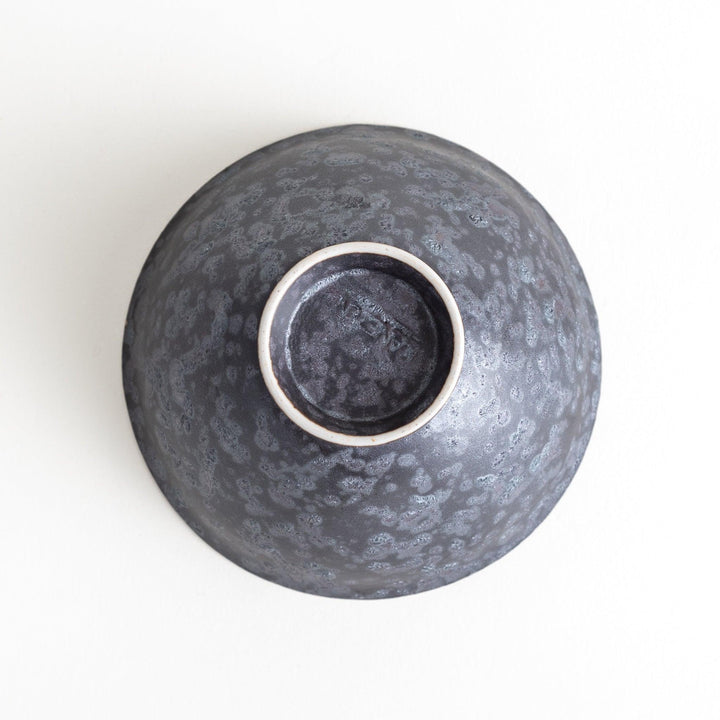 Matte ceramic rice bowls, one in black and the other in white, with a simple, elegant design.