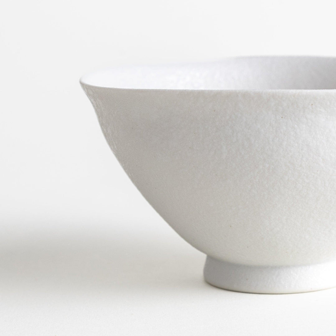 Matte ceramic rice bowls, one in black and the other in white, with a simple, elegant design.