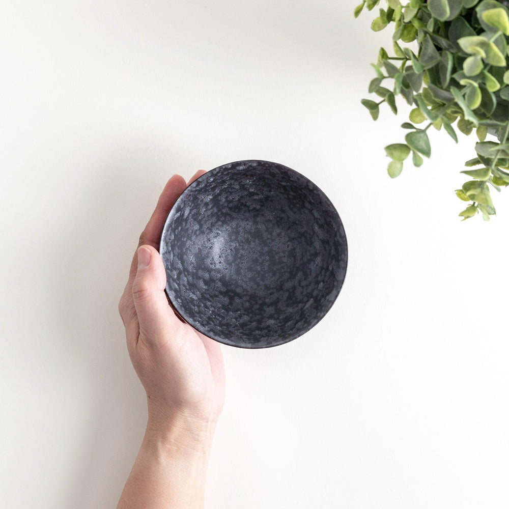 Matte ceramic rice bowls, one in black and the other in white, with a simple, elegant design.