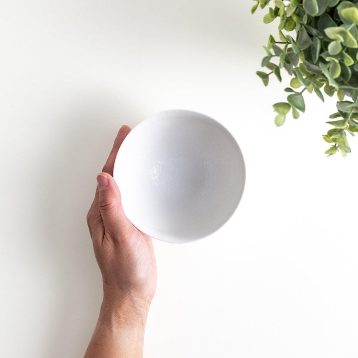 Matte ceramic rice bowls, one in black and the other in white, with a simple, elegant design.