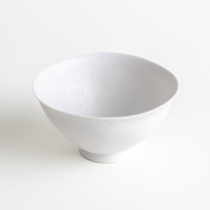 Matte ceramic rice bowls, one in black and the other in white, with a simple, elegant design.