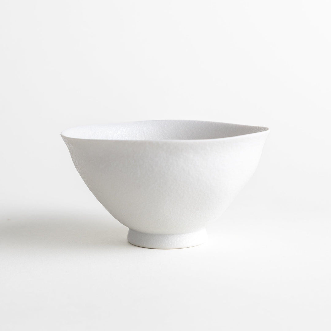 Matte ceramic rice bowls, one in black and the other in white, with a simple, elegant design.