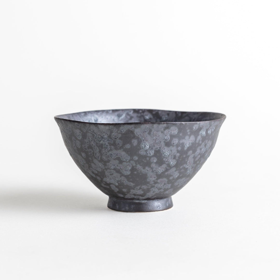 Matte ceramic rice bowls, one in black and the other in white, with a simple, elegant design.