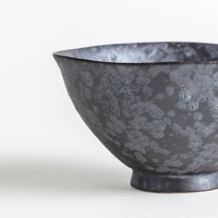 Matte ceramic rice bowls, one in black and the other in white, with a simple, elegant design.