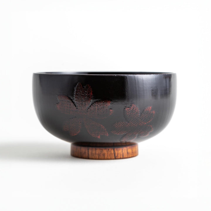 A lacquer bowl featuring a textured floral design and a wooden base. Available in black or red.