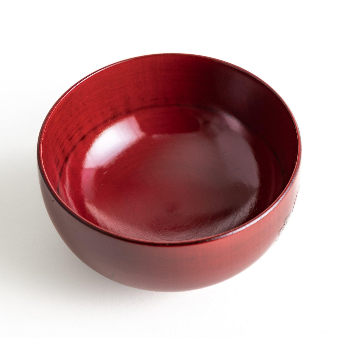 A lacquer bowl featuring a textured floral design and a wooden base. Available in black or red.