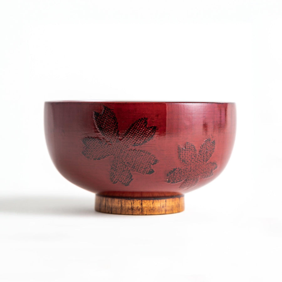 A lacquer bowl featuring a textured floral design and a wooden base. Available in black or red.