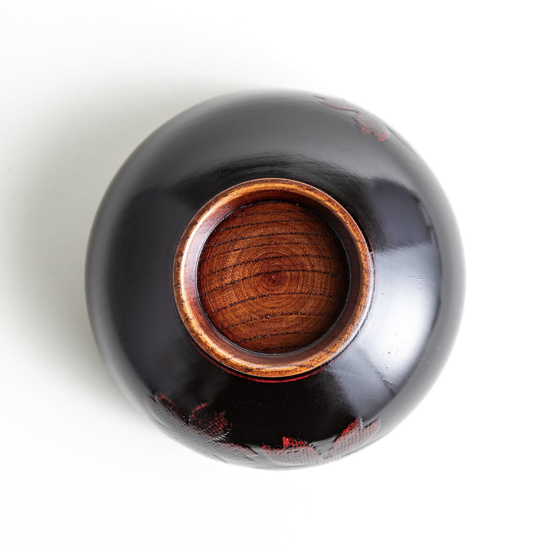 A lacquer bowl featuring a textured floral design and a wooden base. Available in black or red.