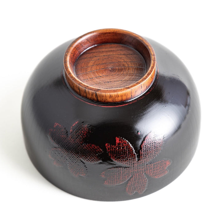 A lacquer bowl featuring a textured floral design and a wooden base. Available in black or red.