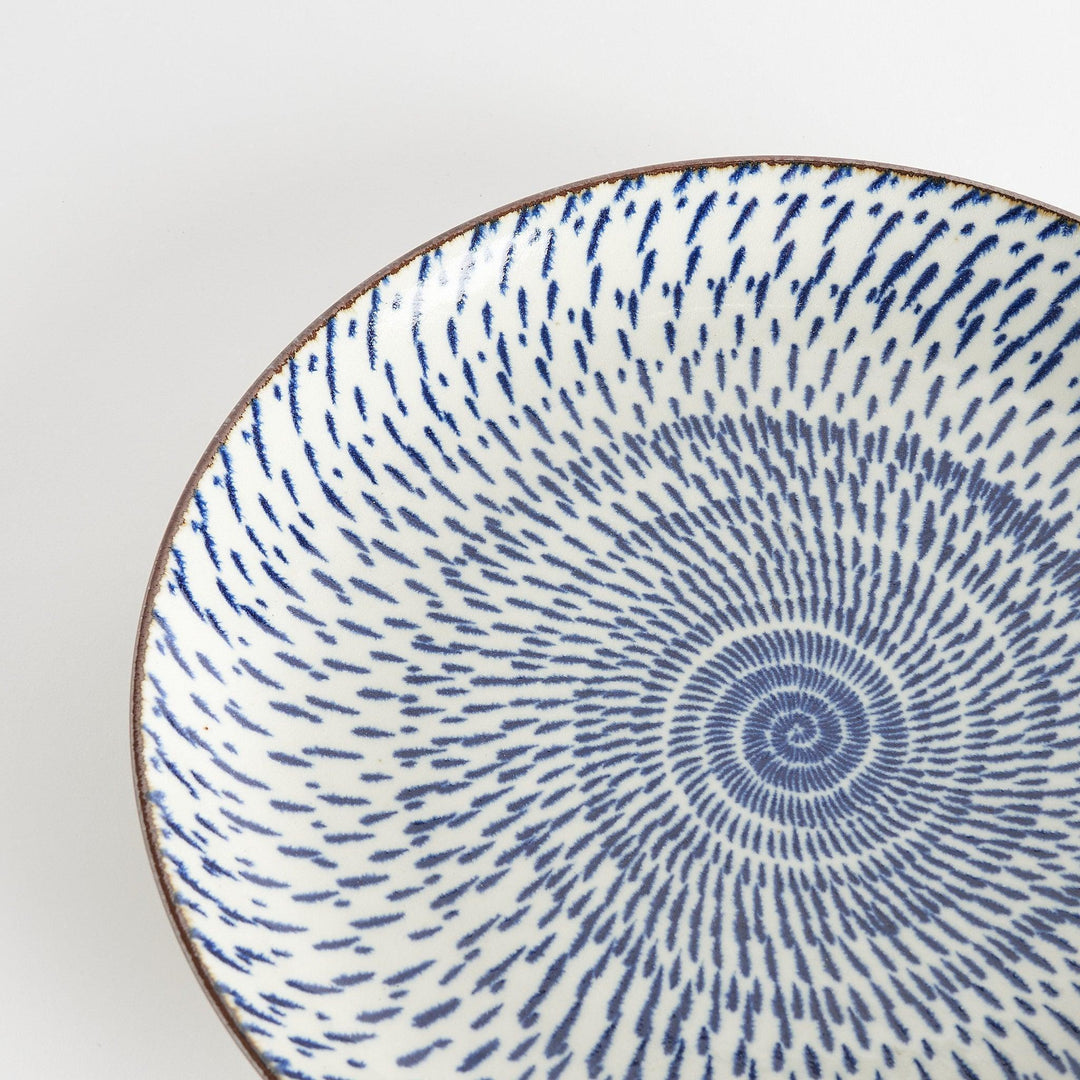 A round serving plate featuring a striking blue radial burst design from the center.