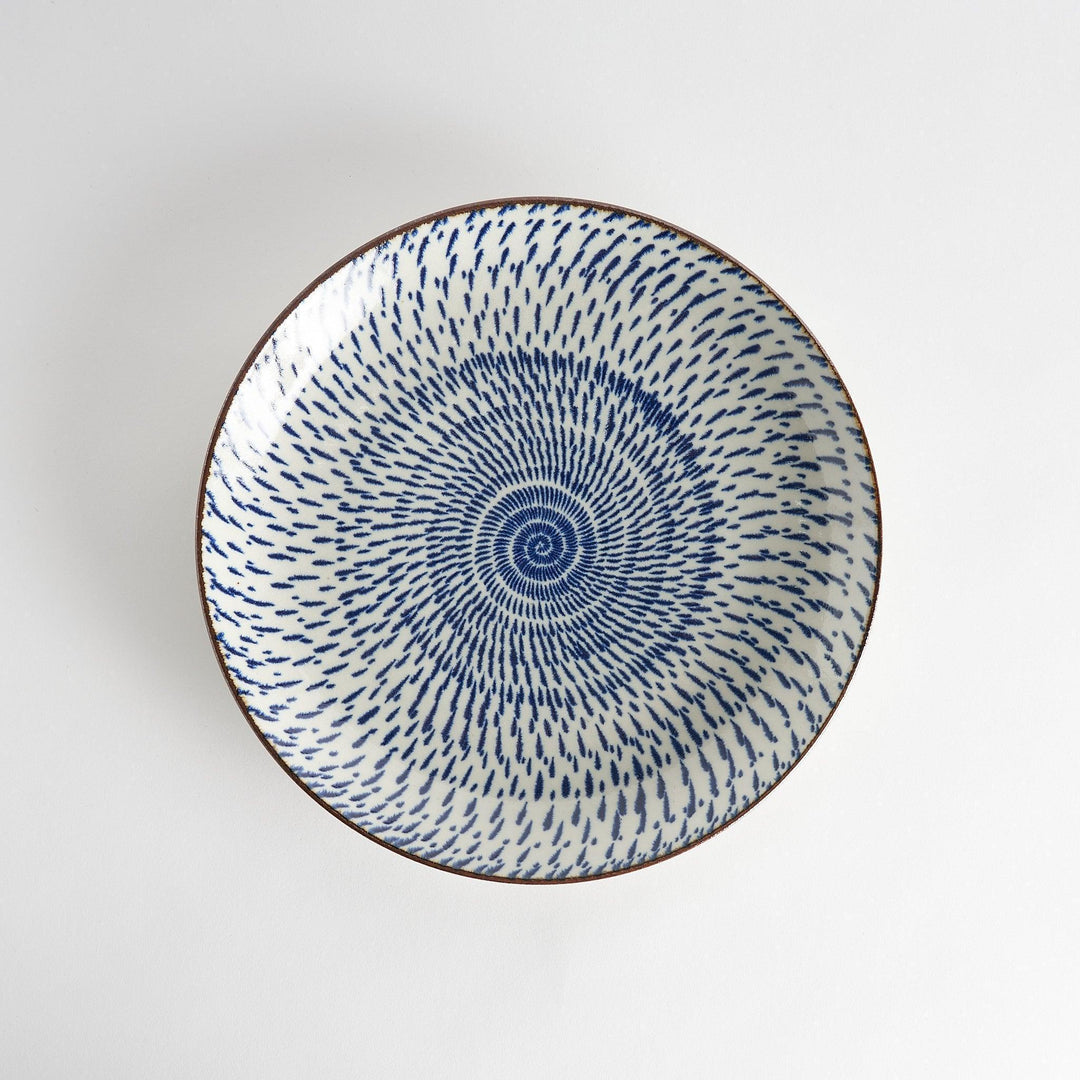 A round serving plate featuring a striking blue radial burst design from the center.