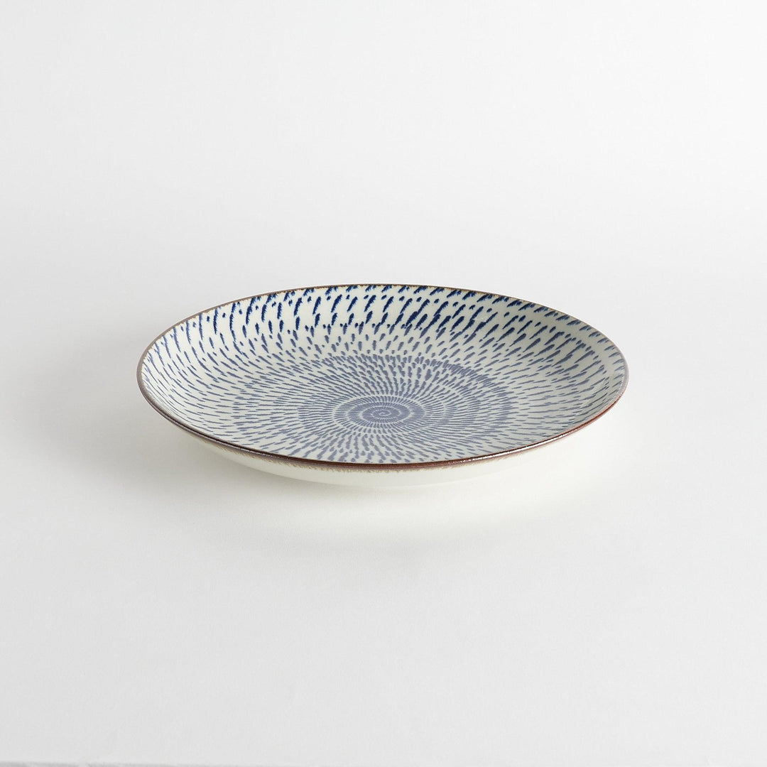 A round serving plate featuring a striking blue radial burst design from the center.