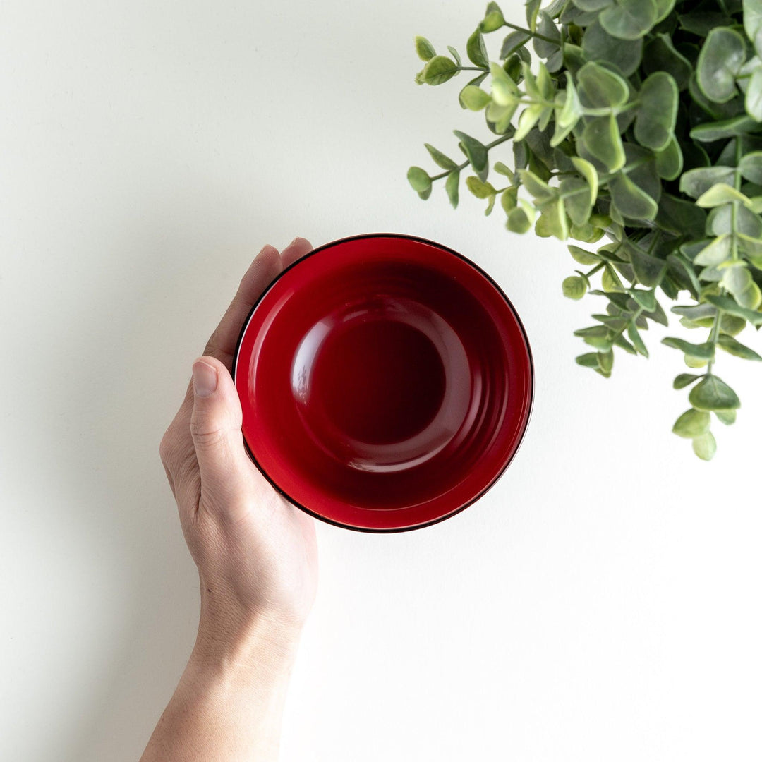 Traditional black lacquer bowl with red interior and gold cherry blossom motif.