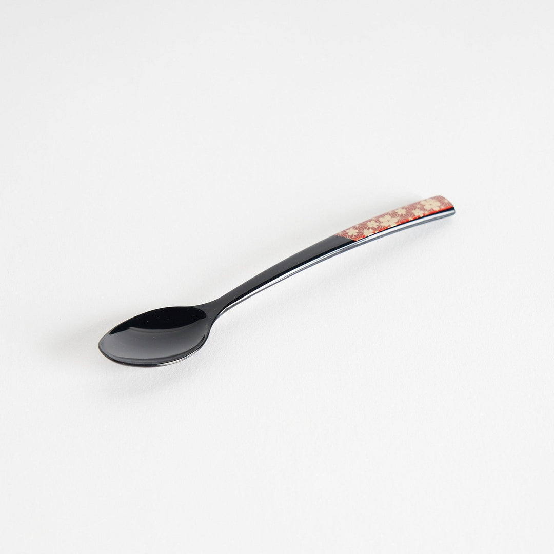 A set of two coffee spoons, one red and one black, featuring a detailed sakura pattern in gold on the handles.