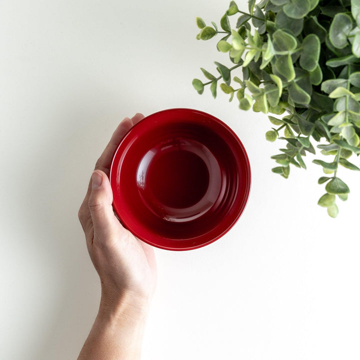 Traditional red lacquer bowl with gold cherry blossom motif, featuring a glossy finish.