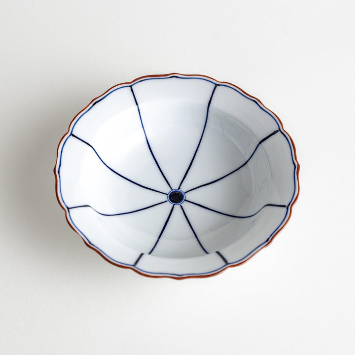 A ceramic bowl with a blue spiderweb-like pattern and scalloped edges.