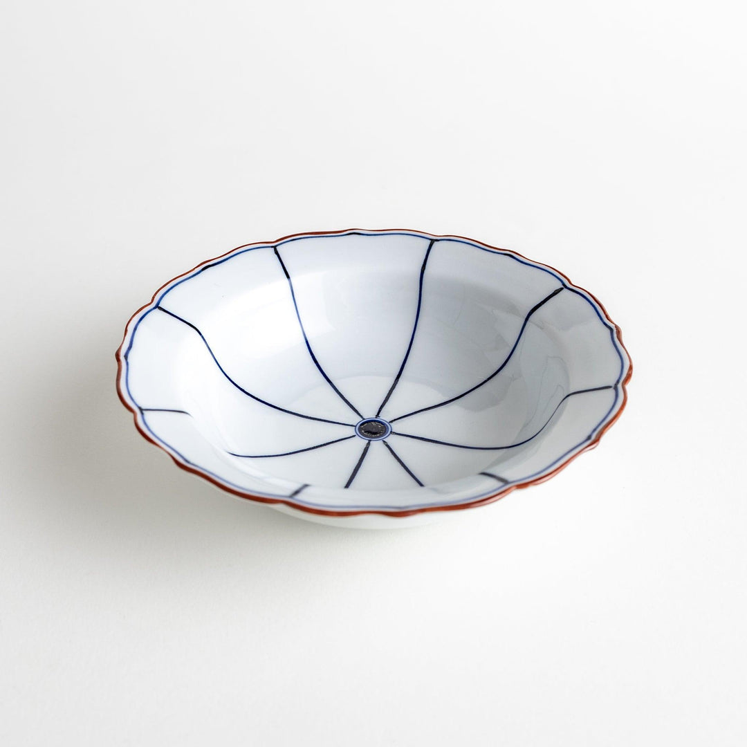 A ceramic bowl with a blue spiderweb-like pattern and scalloped edges.