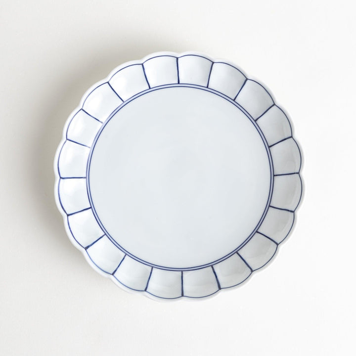 White salad plate with scalloped edges, outlined in a thin blue or red line.