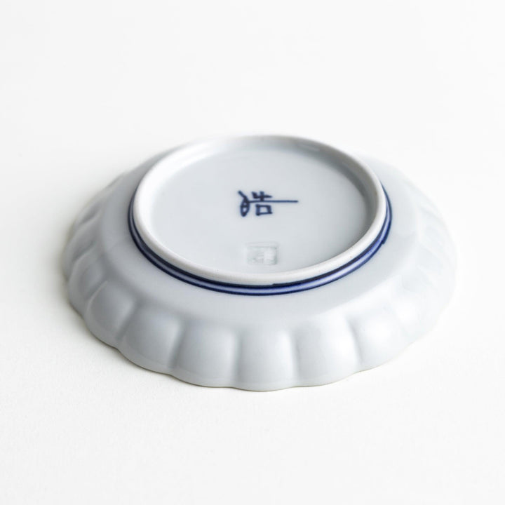 White sauce dish with scalloped edges, outlined in a thin blue or red line.