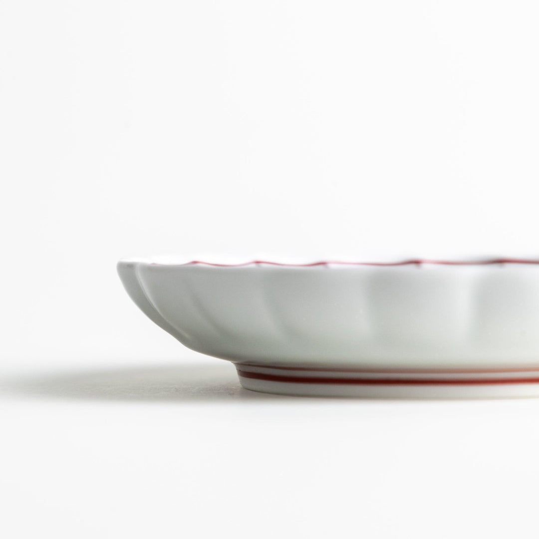 White sauce dish with scalloped edges, outlined in a thin blue or red line.