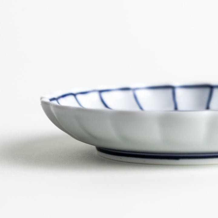 White sauce dish with scalloped edges, outlined in a thin blue or red line.