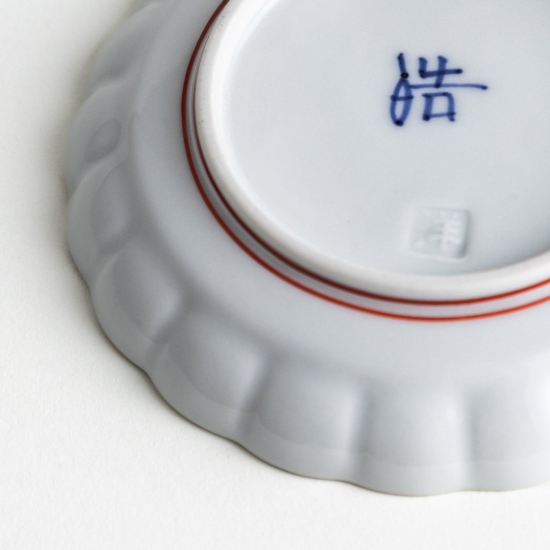 White sauce dish with scalloped edges, outlined in a thin blue or red line.