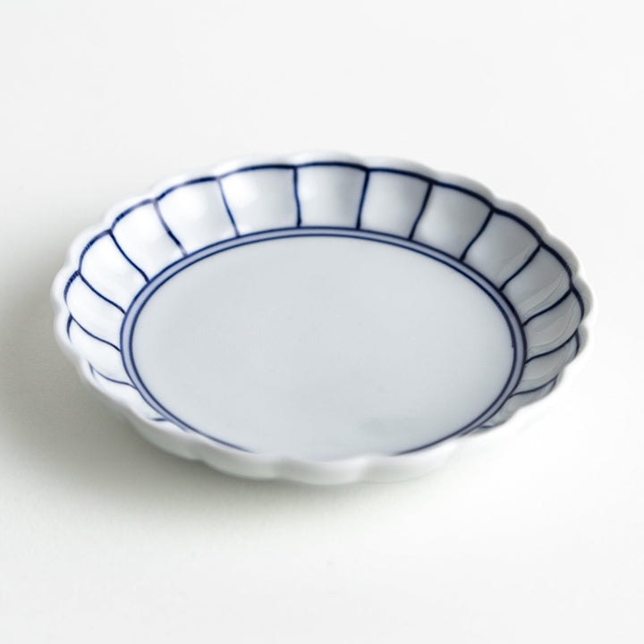 White sauce dish with scalloped edges, outlined in a thin blue or red line.