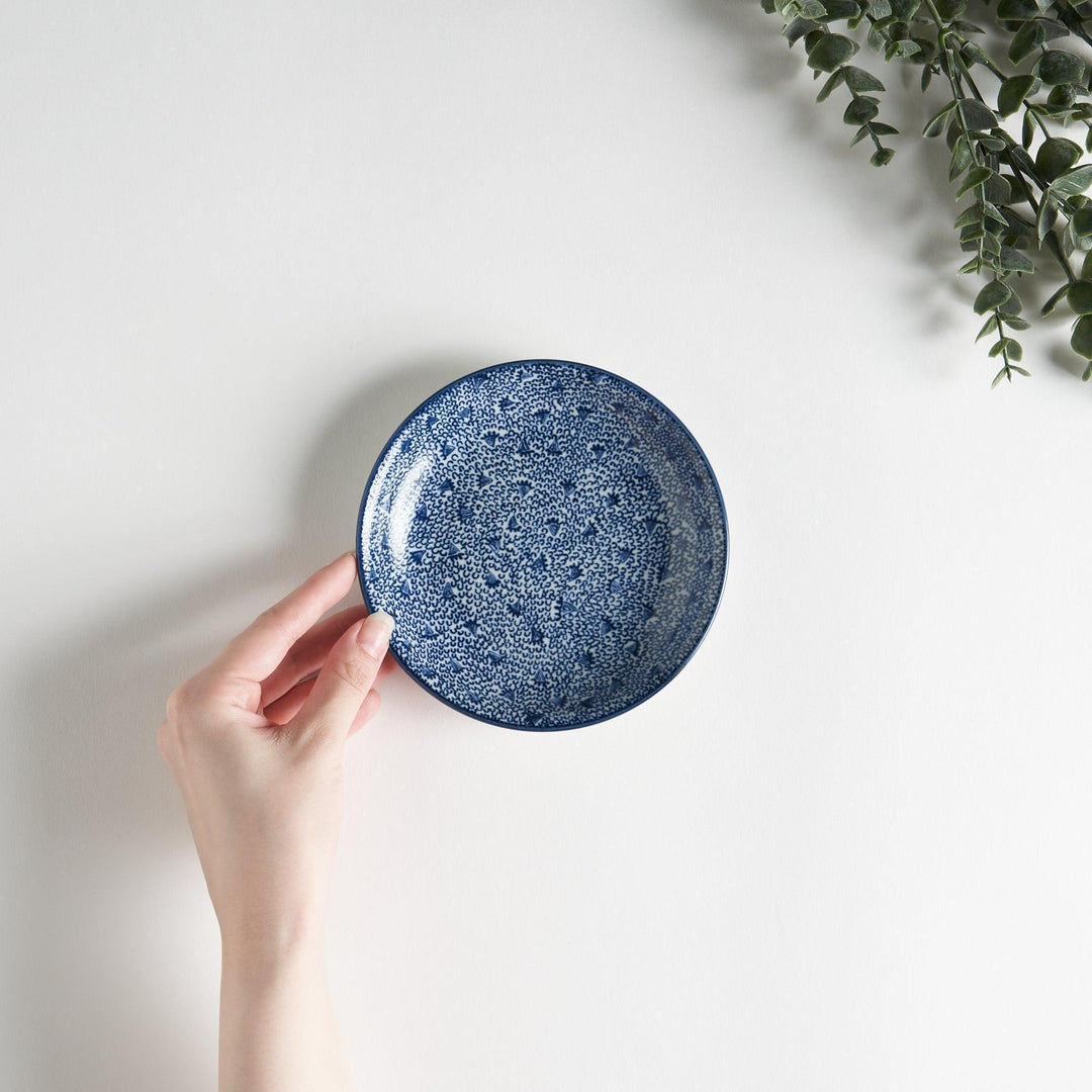 A shallow round plate with a speckled blue pattern covering the surface.