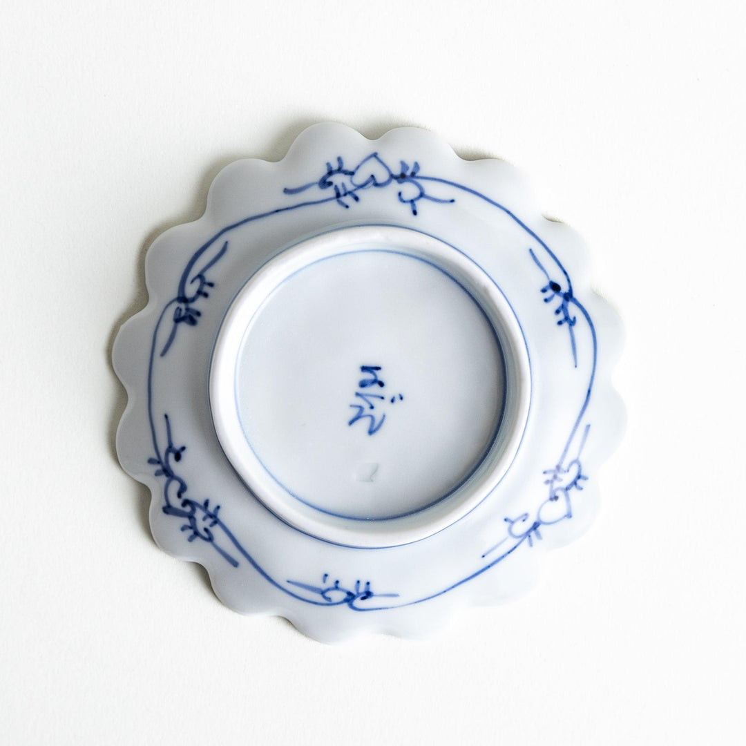 White plate with blue floral designs and a scalloped edge.
