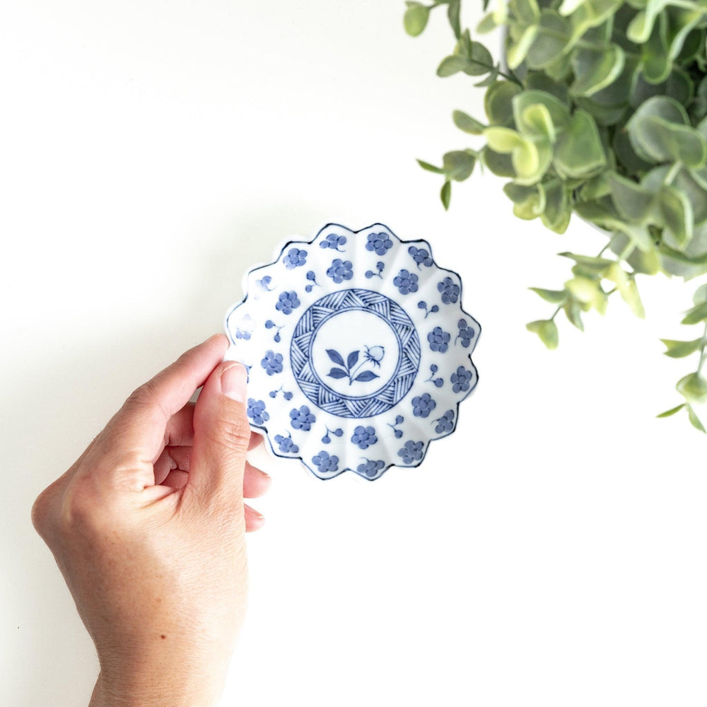 White plate with blue floral designs and a scalloped edge.
