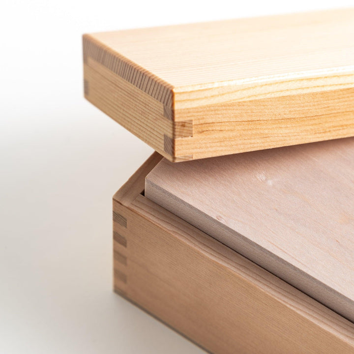 A small wooden box with a sliding drawer and lid, designed for shaving katsuobushi (dried bonito), with a colorful packaging box featuring traditional Japanese artwork.