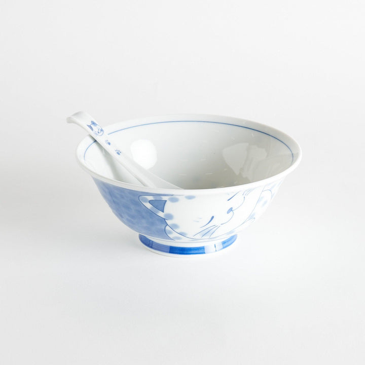 A white porcelain spoon with a blue cat face and paw prints on the handle.