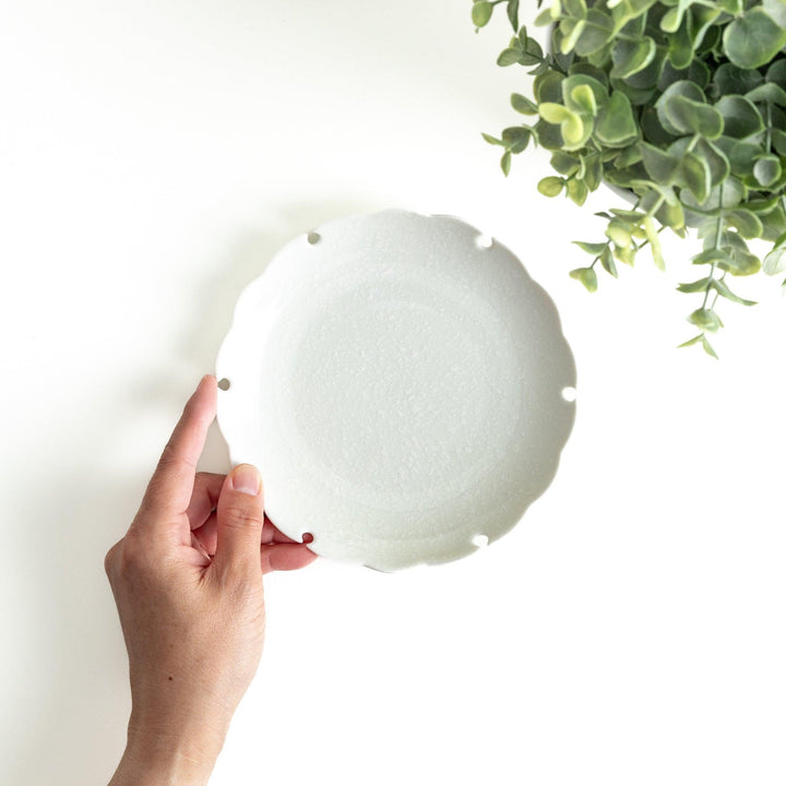 Ceramic dessert plates with scalloped edges, available in black and white.