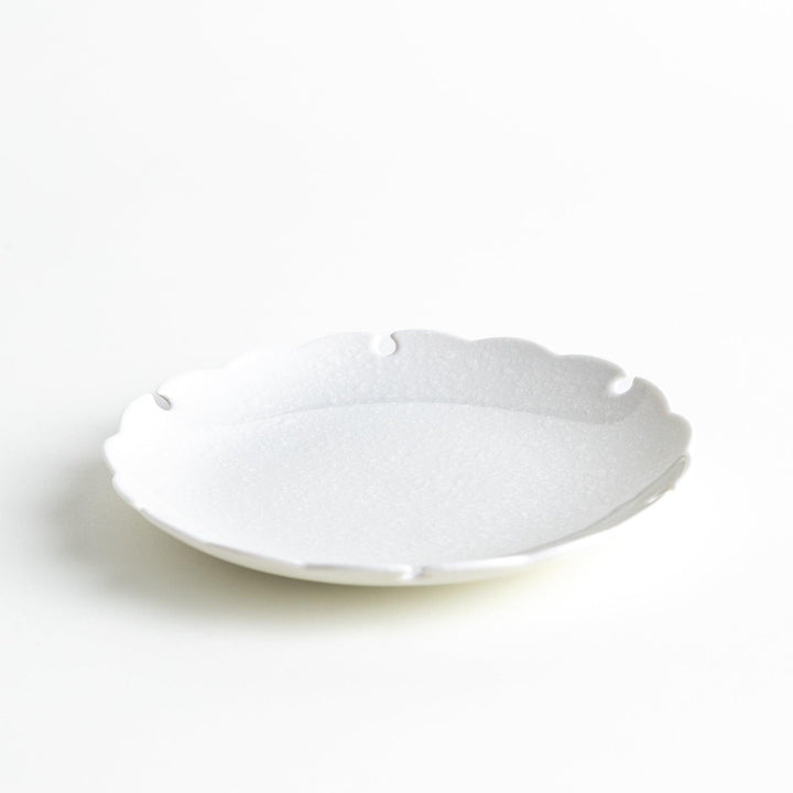 Ceramic dessert plates with scalloped edges, available in black and white.