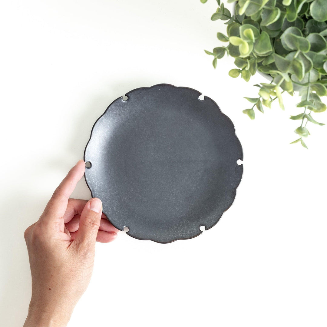 Ceramic dessert plates with scalloped edges, available in black and white.