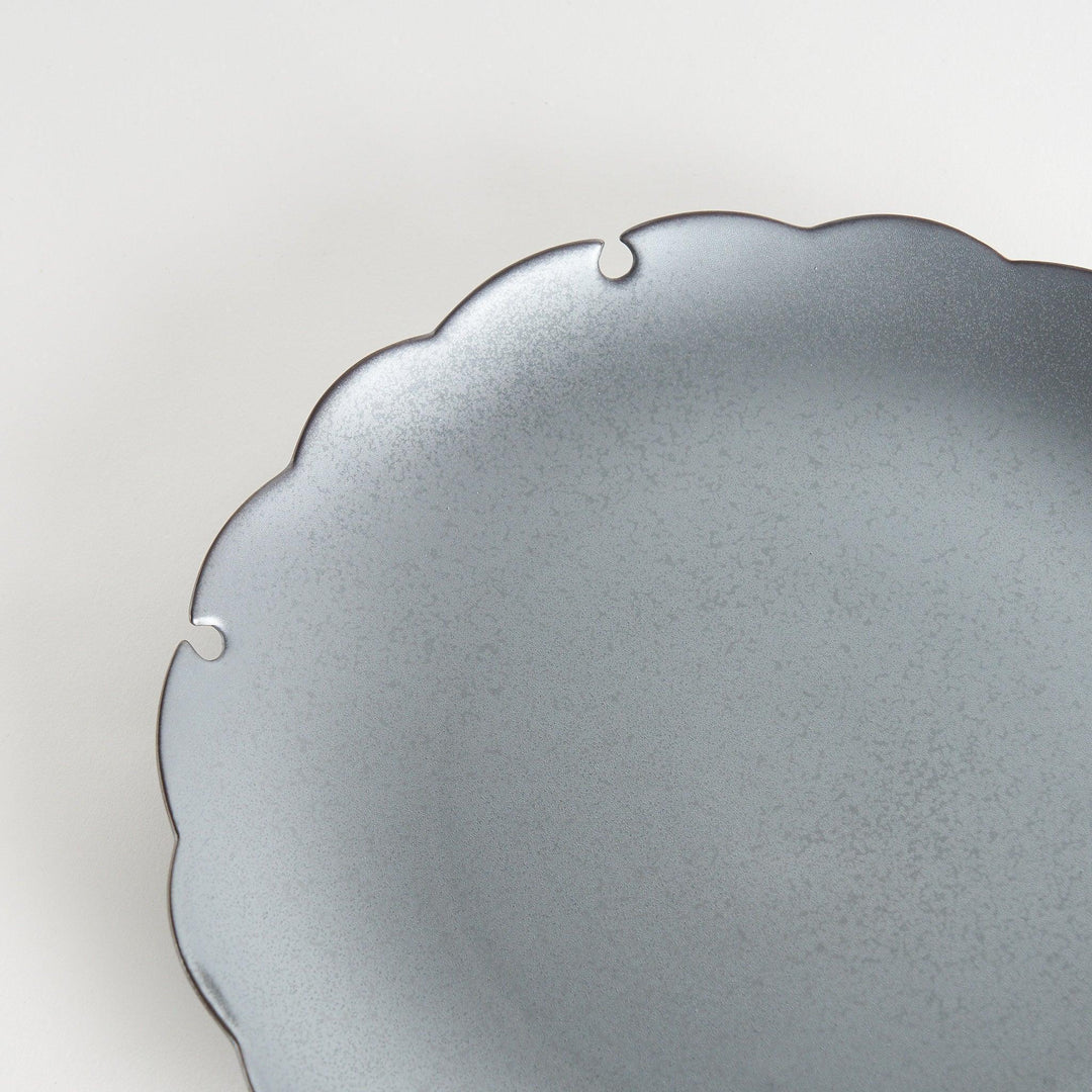 Ceramic dinner plates with scalloped edges, available in black and white.